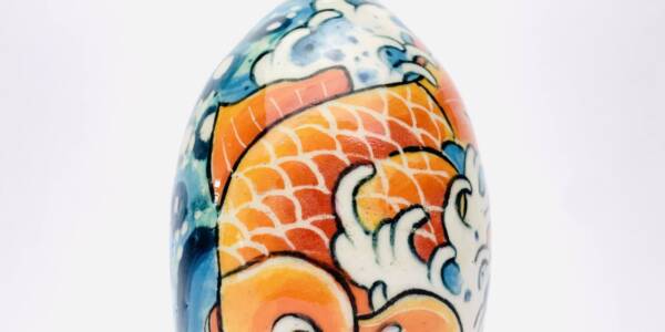 ceramic vase with tattoo art of a fish blue and orange in color